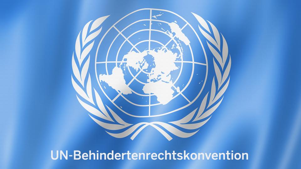 Flagge der Verienten Nationen, darunter steht UN-Behindertenrechtskonvention